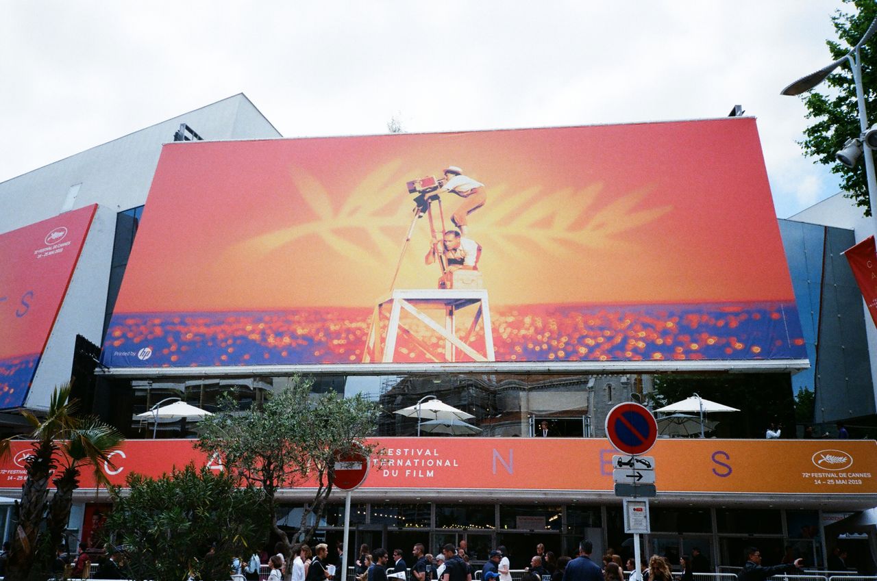 Menu Large billboard at the Cannes Film Festival showcasing vibrant imagery.